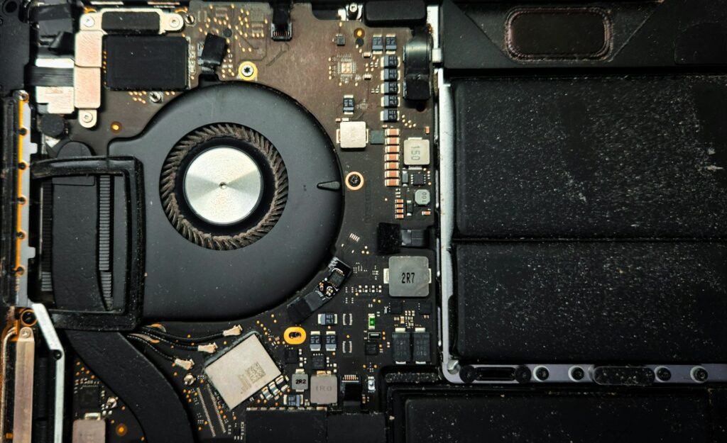 Inside view of a laptop showing fan, battery, and motherboard components. Laptop not turning on?